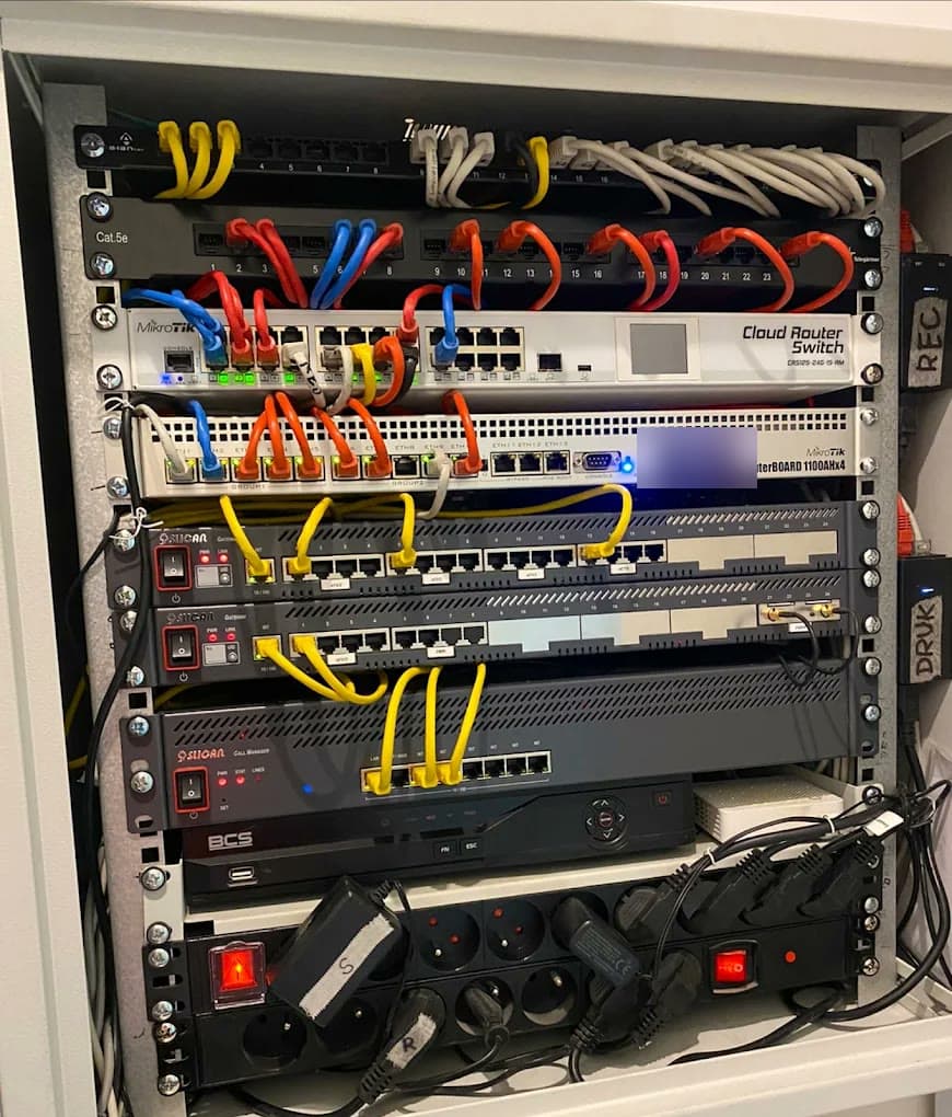 Uporządkowana szafa rack z przełącznikami sieciowymi, centralą telefoniczną i rejestratorem kamer